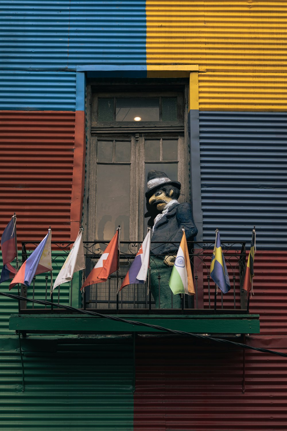 a colorful building with a statue of a man on a balcony