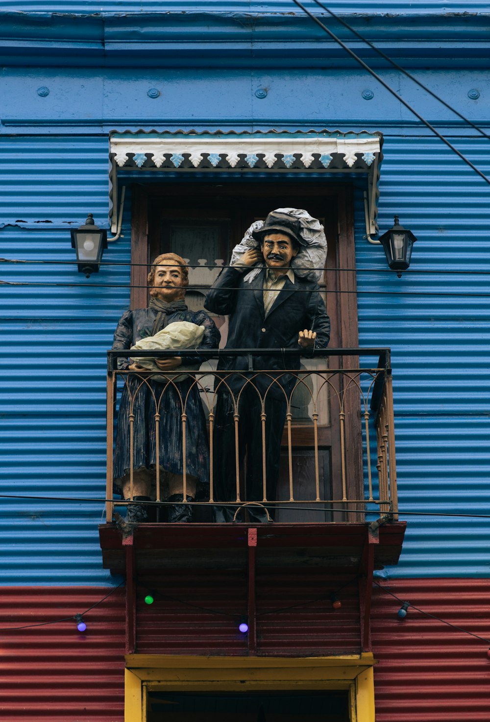 Un couple de statues de personnes sur un balcon