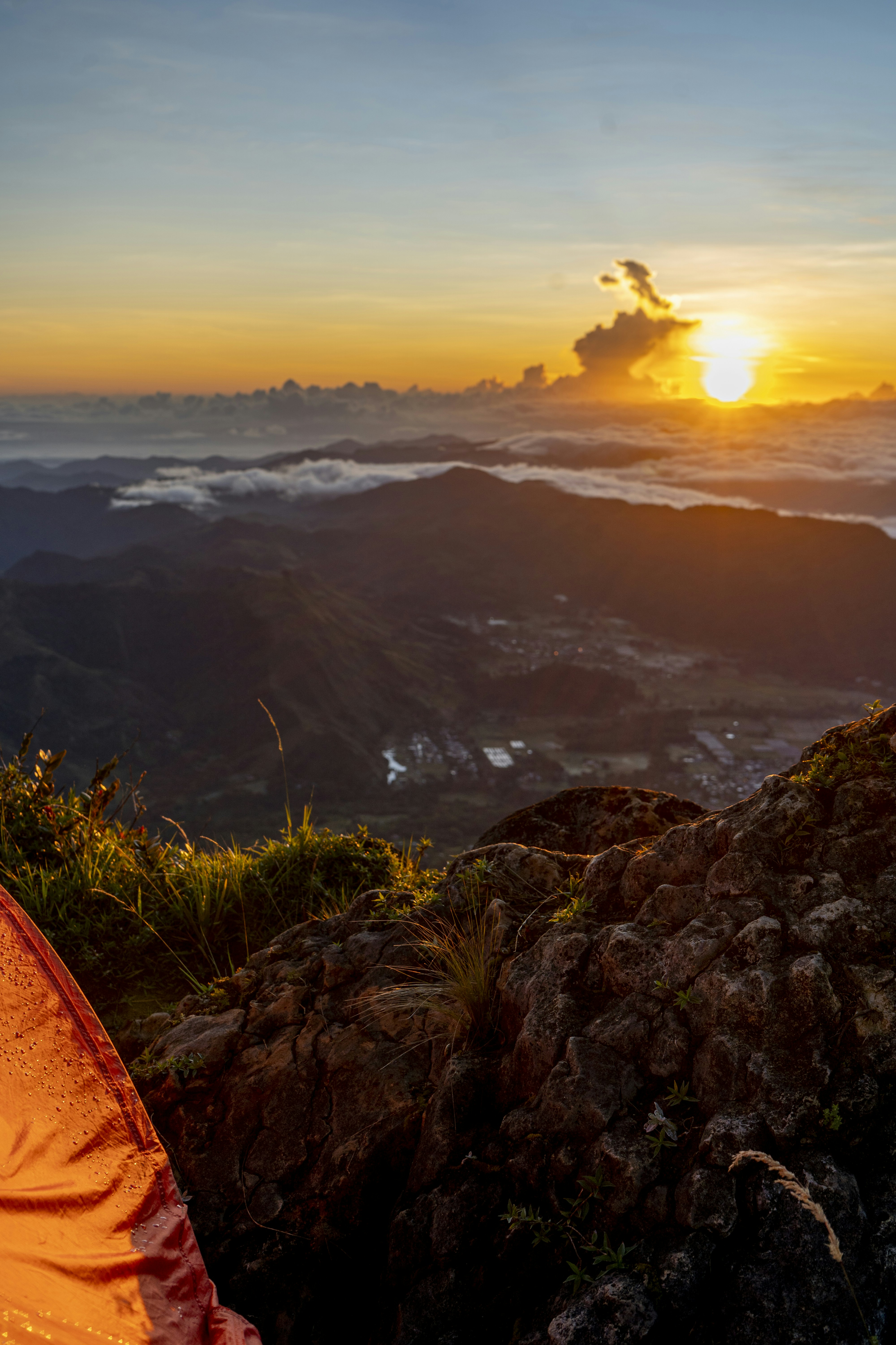 a tent sitting on top of a lush green hillside