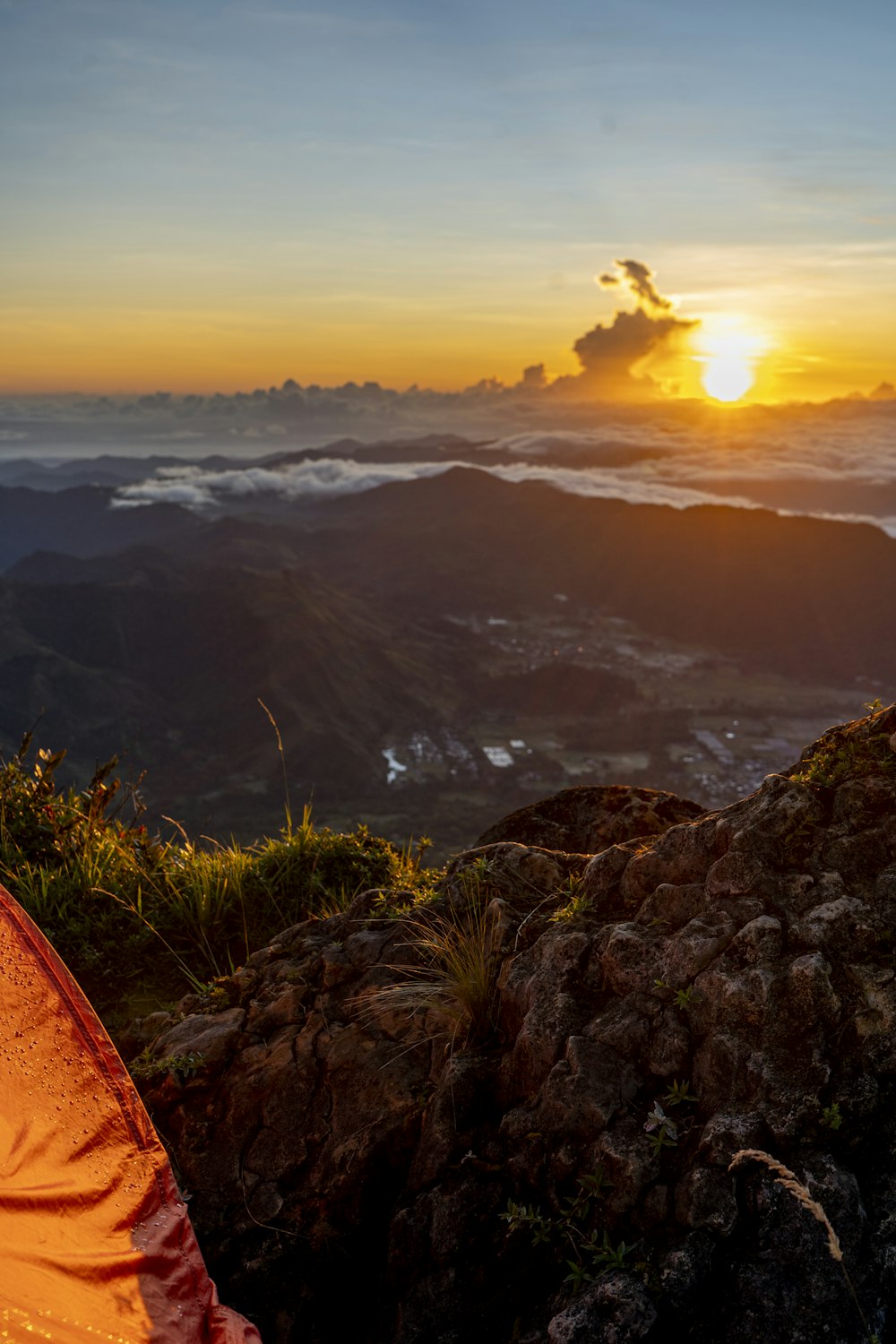 a tent sitting on top of a lush green hillside