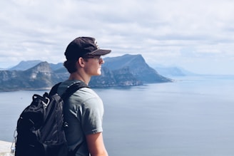 a man with a backpack looks out over the water