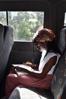 a young girl sitting in the back seat of a car
