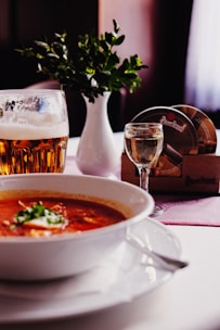 A cozy setup with probiotic jars and bone broth bowls on a wooden table.