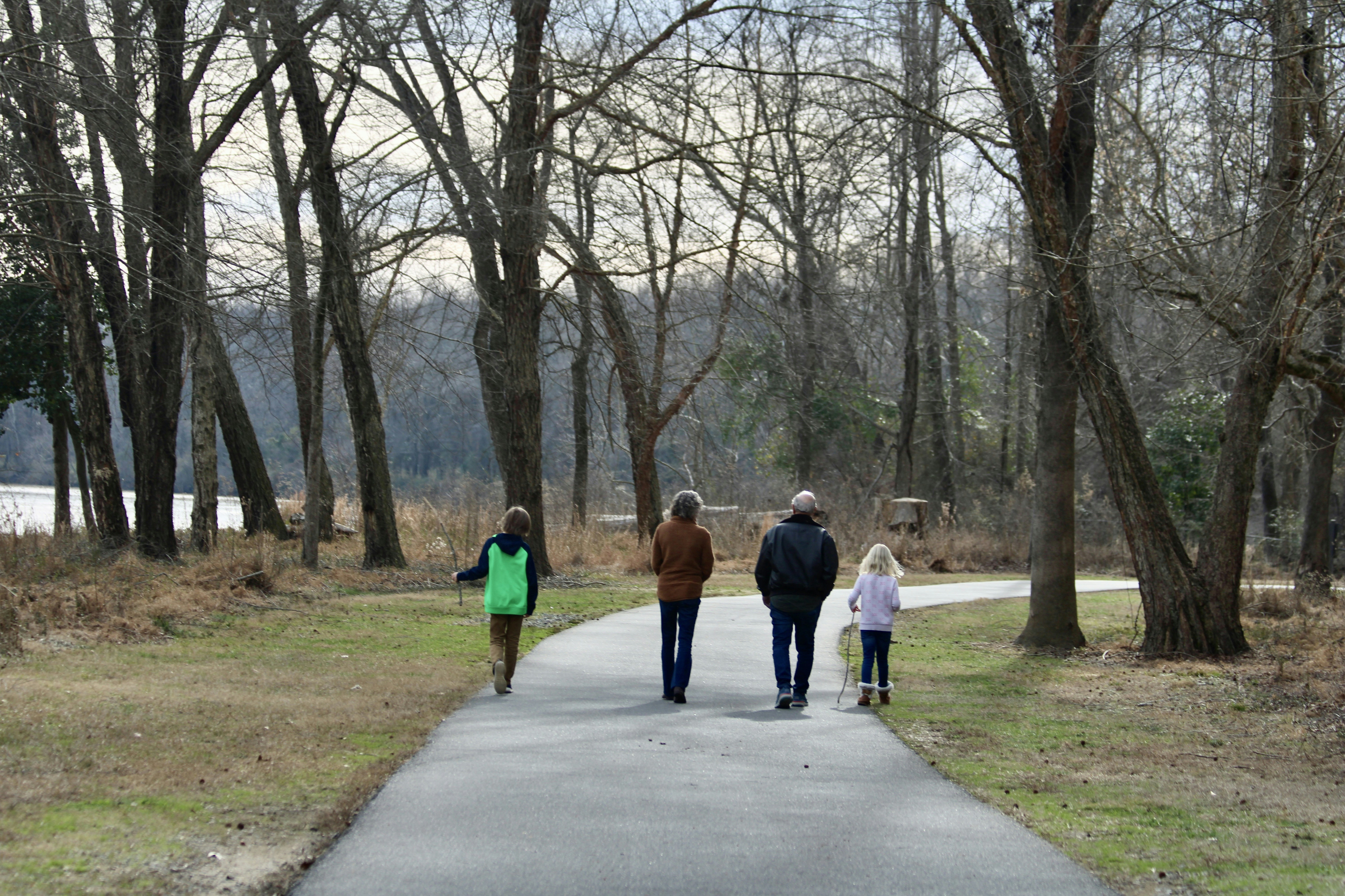 a group of people walking down a path in a park