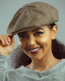 Side view of a tucker deacon cap worn by a smiling person outdoors.