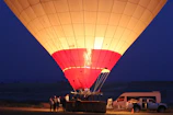 A group of happy travelers preparing for a hot air balloon ride at sunset