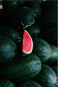 a pile of watermelon with a slice cut out of it