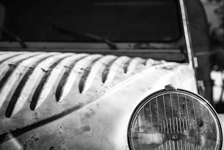 A close-up of a weathered vintage car hood with rich oxide patina under soft natural light.