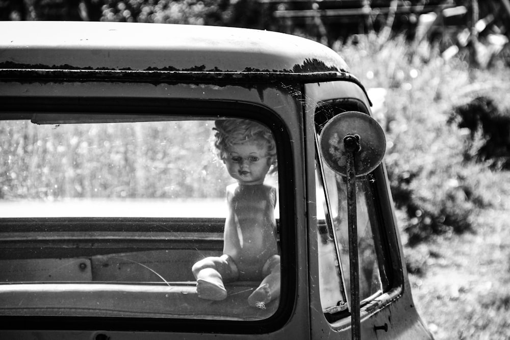 a baby sitting in the back of a truck