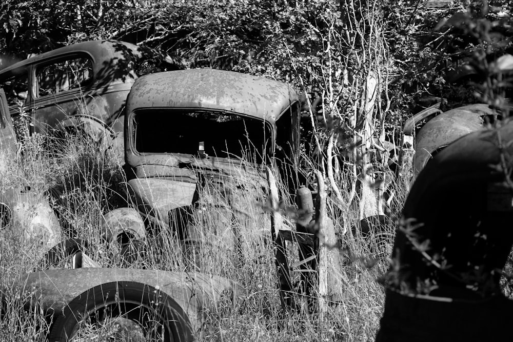 a black and white photo of an old truck in a field