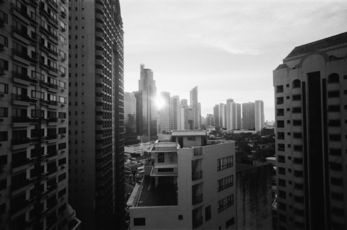 A black and white photograph capturing urban architecture at dusk.