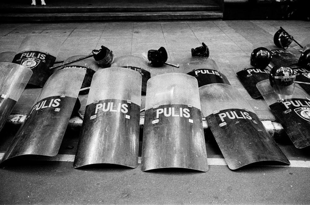 black and white photograph of a bunch of police batons laying on the ground