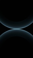 A minimalist design featuring two large, smooth, curved shapes that resemble abstract spheres. The color is a subtle gradient of dark blues against a black background, giving a futuristic and celestial appearance.