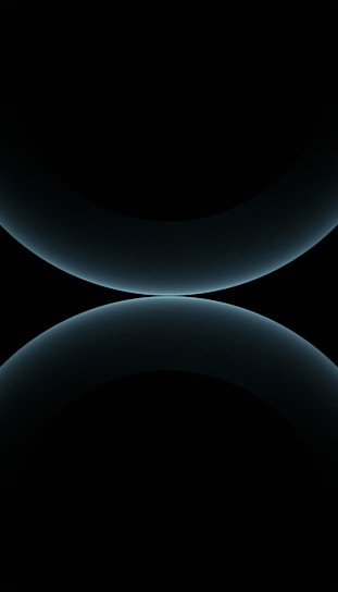 A minimalist design featuring two large, smooth, curved shapes that resemble abstract spheres. The color is a subtle gradient of dark blues against a black background, giving a futuristic and celestial appearance.