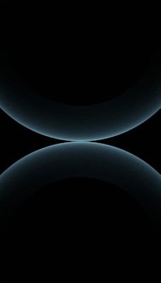A minimalist design featuring two large, smooth, curved shapes that resemble abstract spheres. The color is a subtle gradient of dark blues against a black background, giving a futuristic and celestial appearance.
