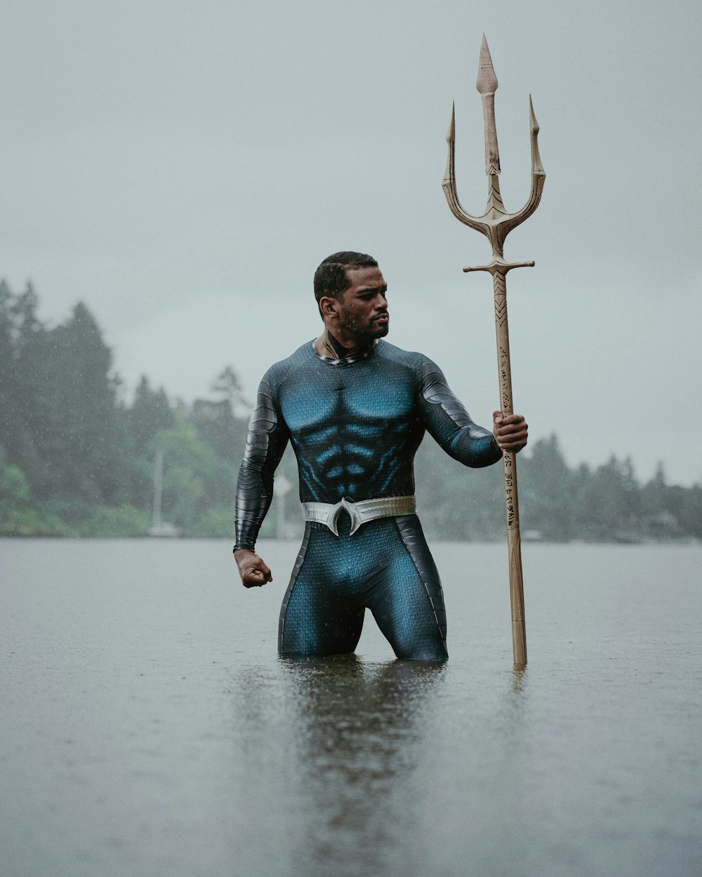 Un hombre con un traje azul sosteniendo un palo grande