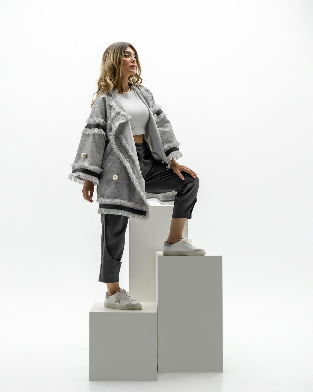 a woman sitting on top of a white block