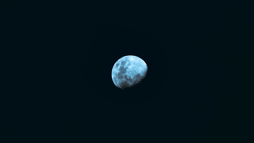 a blue moon is seen in the dark sky