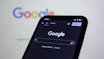 a close up of a cell phone with the google logo in the background