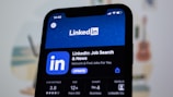 the linkedin logo is displayed on a smartphone