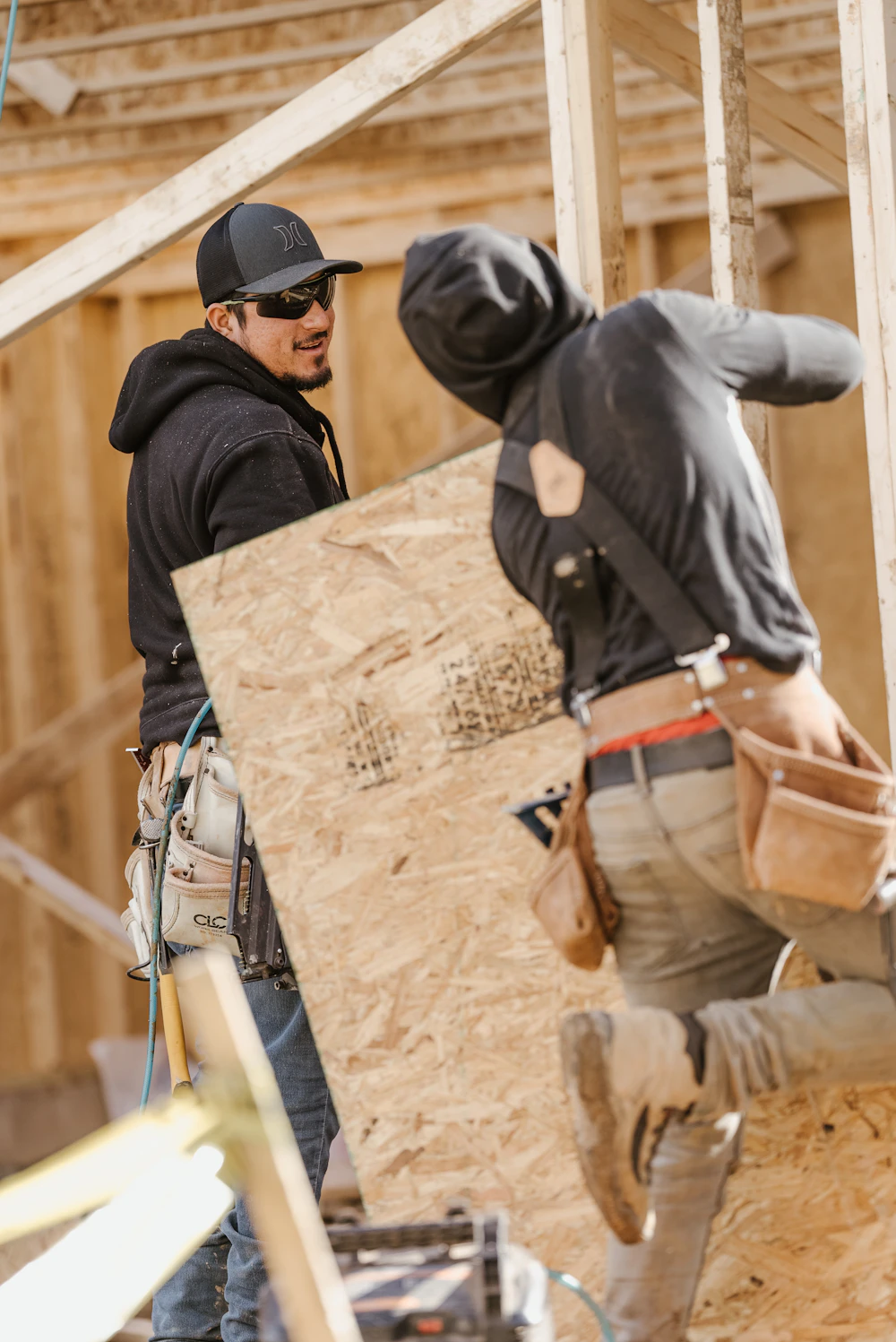 Construction workers reviewing residential framing work