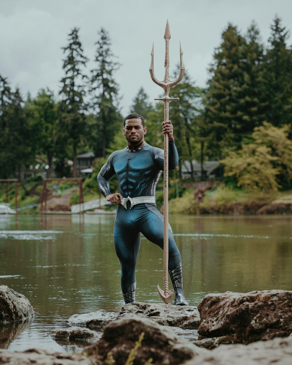 a man in a wet suit holding a large stick