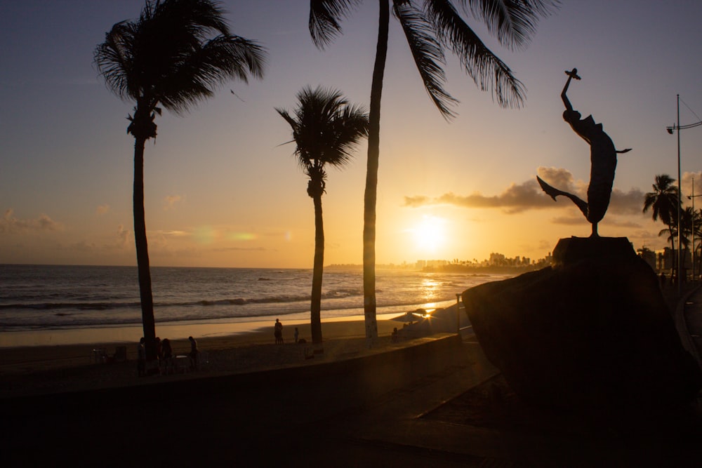 a statue of a person on a surfboard on a beach