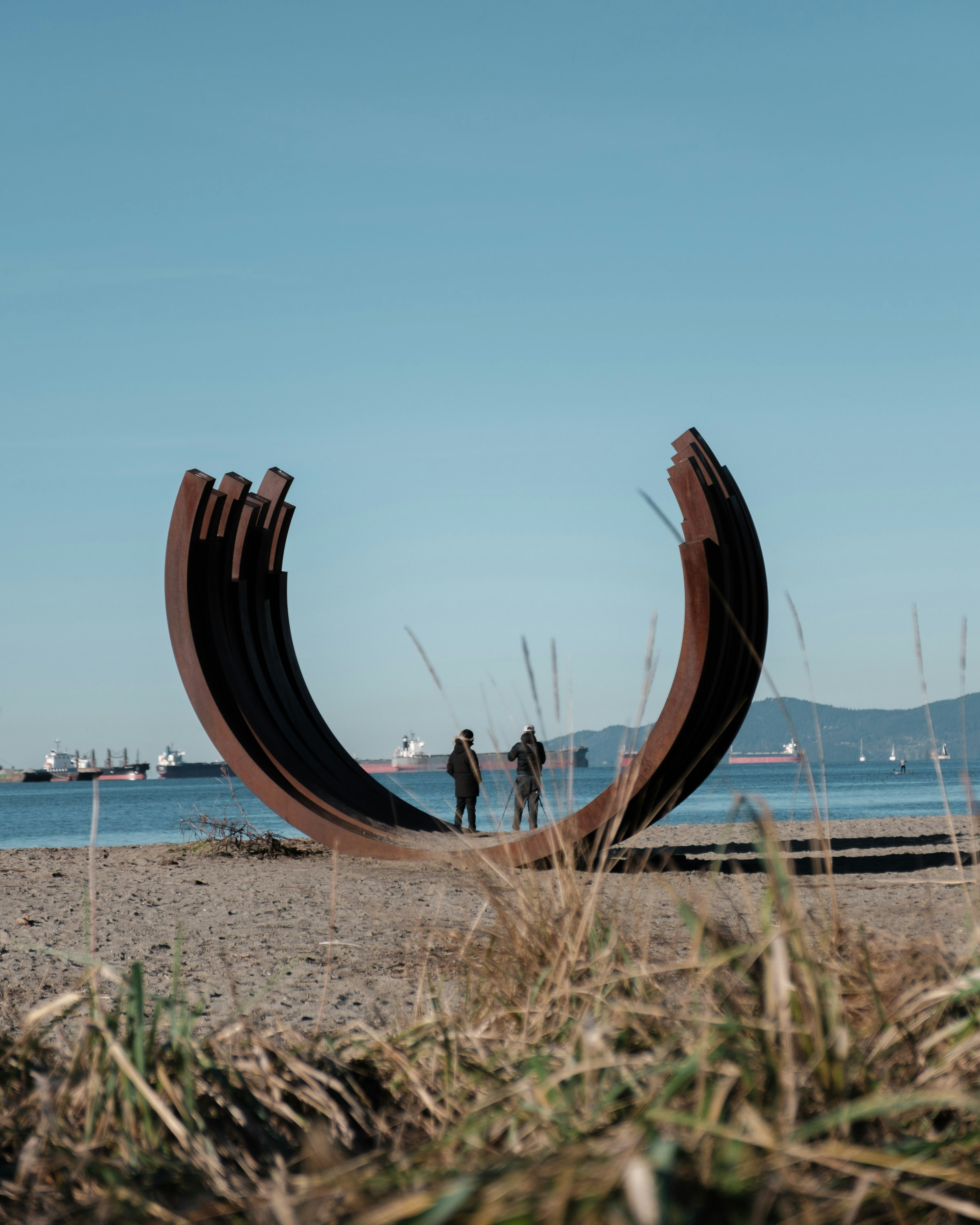 Un couple de personnes debout au sommet d’une plage de sable