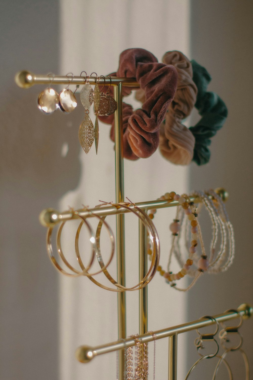 a gold jewelry rack with several pairs of earrings on it