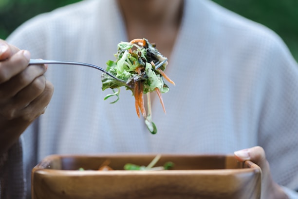 a person eating a salad with a fork