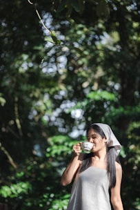 A serene urban woman enjoying a morning tea infused with herbal ingredients