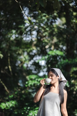 A healthy lifestyle scene with a woman enjoying herbal tea outdoors.