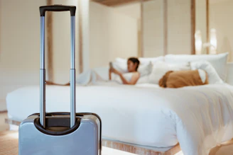 a woman laying on a bed with a suitcase in front of her
