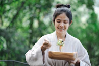 A cheerful person enjoying a healthy lunch outdoors with a colorful salad bowl.