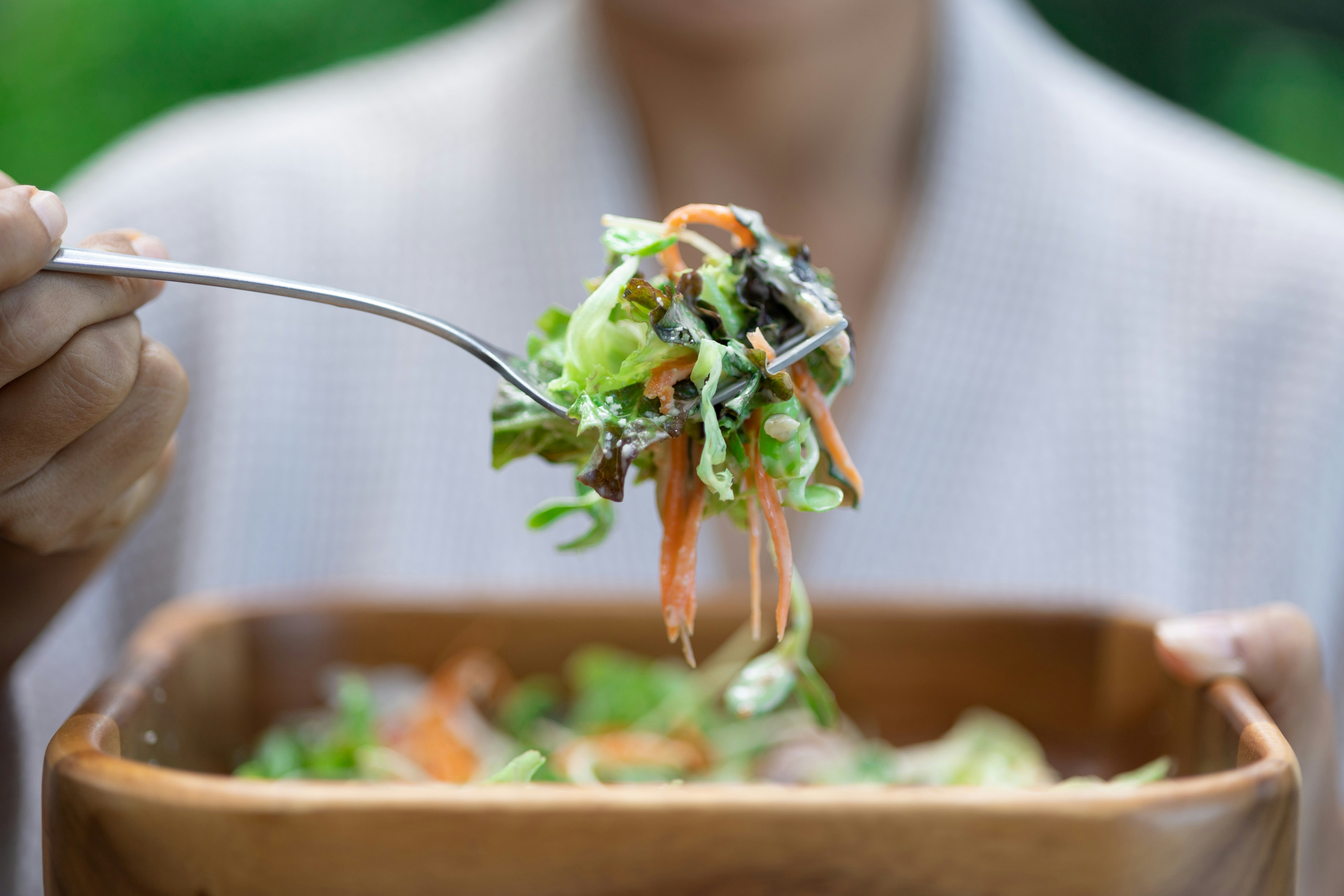 a person eating a salad with a fork