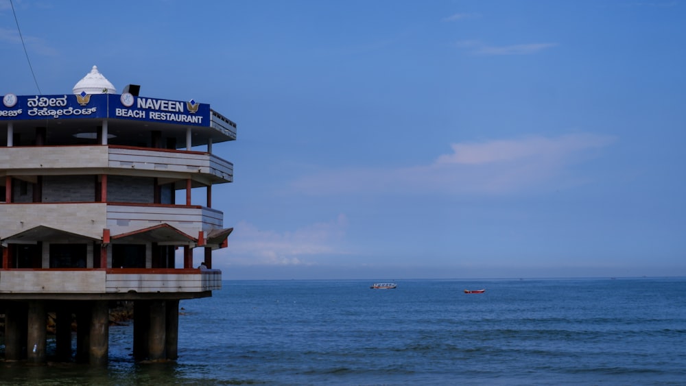 a tall building sitting on top of a beach next to the ocean