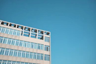 A modern hospital building with clear blue skies in the background.