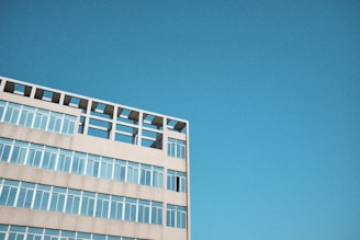 Aerial shot of a modern building with a clear blue sky in the background.