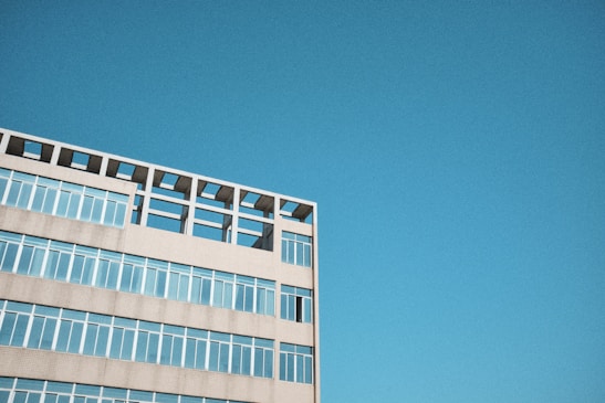 Aerial shot of a modern building with a clear blue sky in the background.