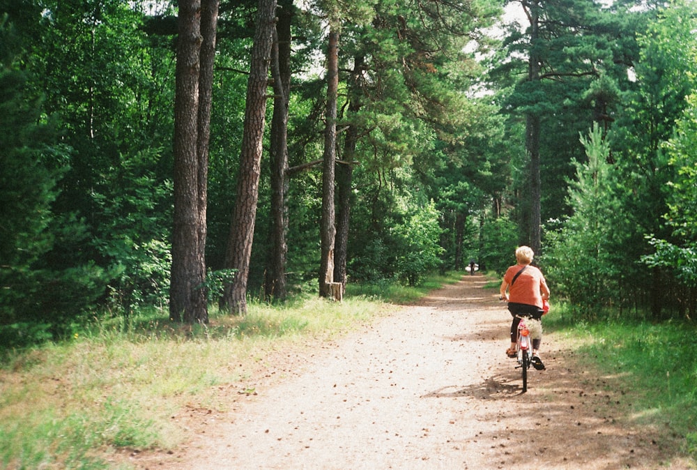 a person riding a bike down a dirt road