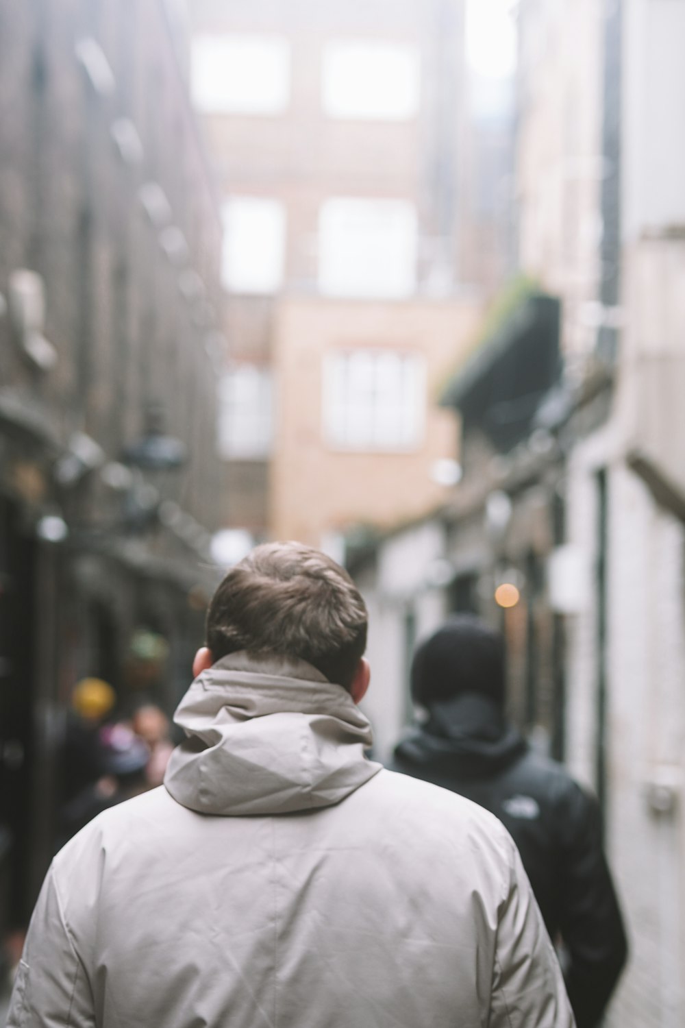 a man walking down a street next to tall buildings