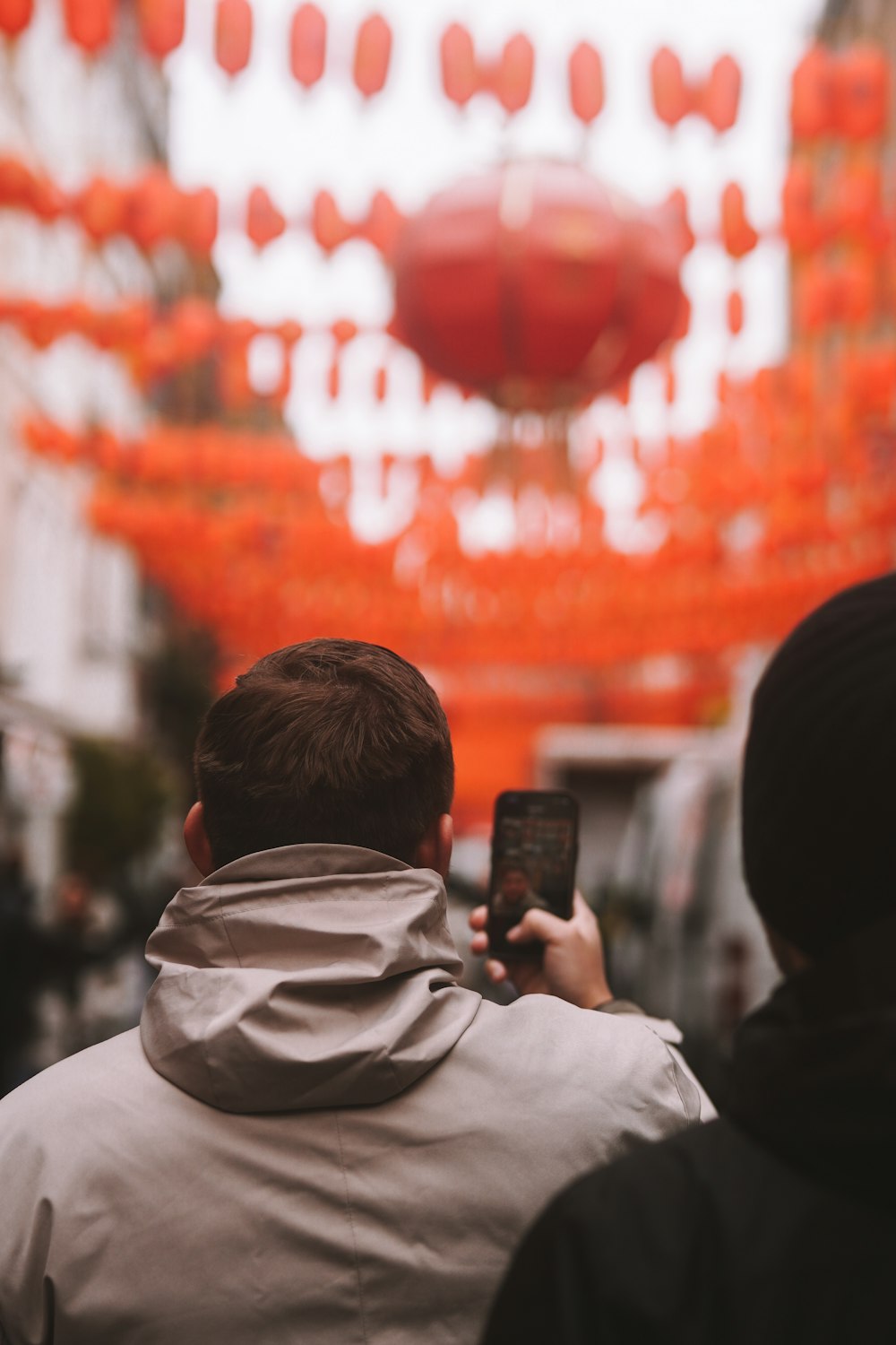 a man taking a picture of a red lantern
