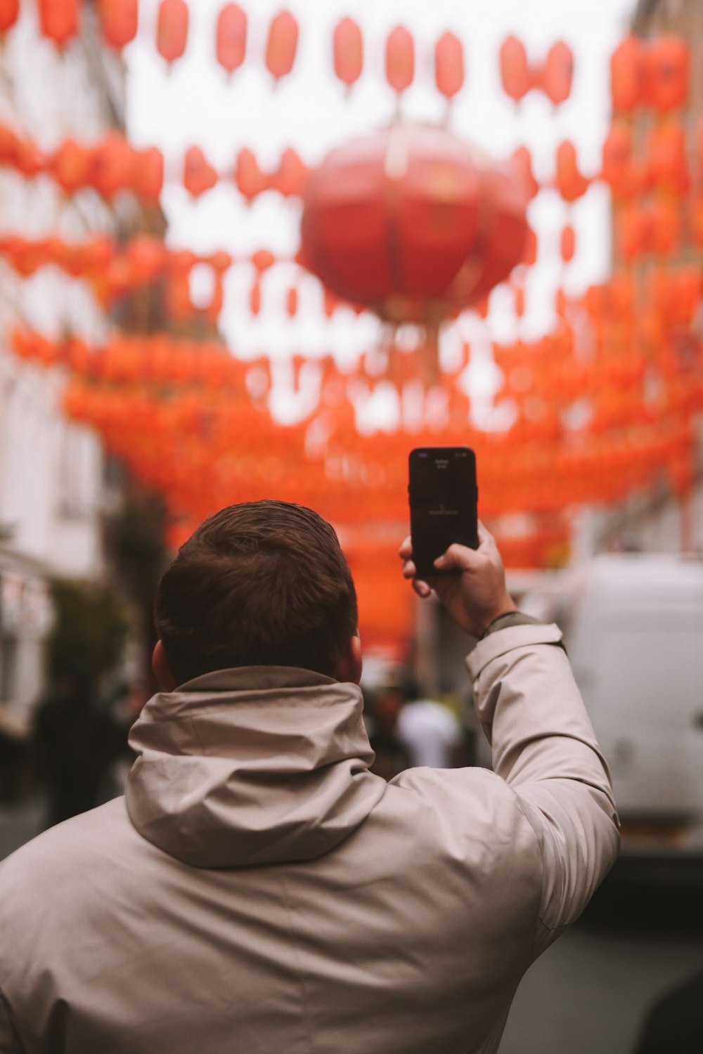 a man taking a picture of a chinese lantern