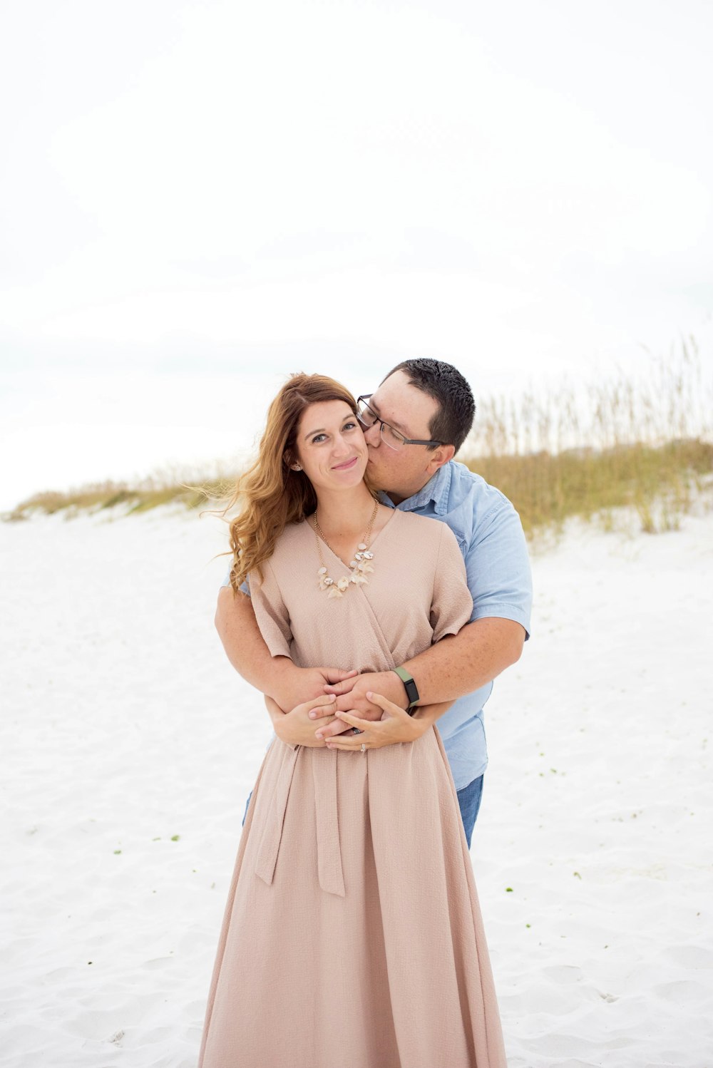 a man and a woman hugging on the beach