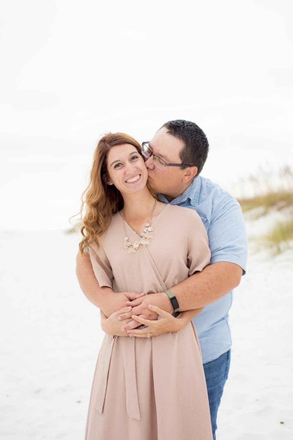 a man and a woman hugging on the beach