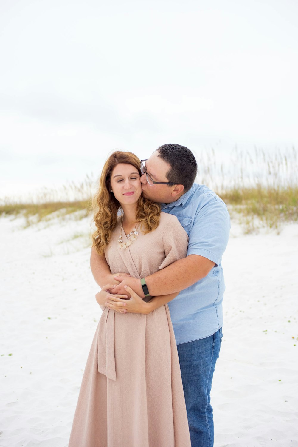 a man kissing a woman on the beach