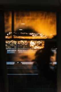 Sunset view through a window with soft light casting warm tones, evoking peaceful reflection.