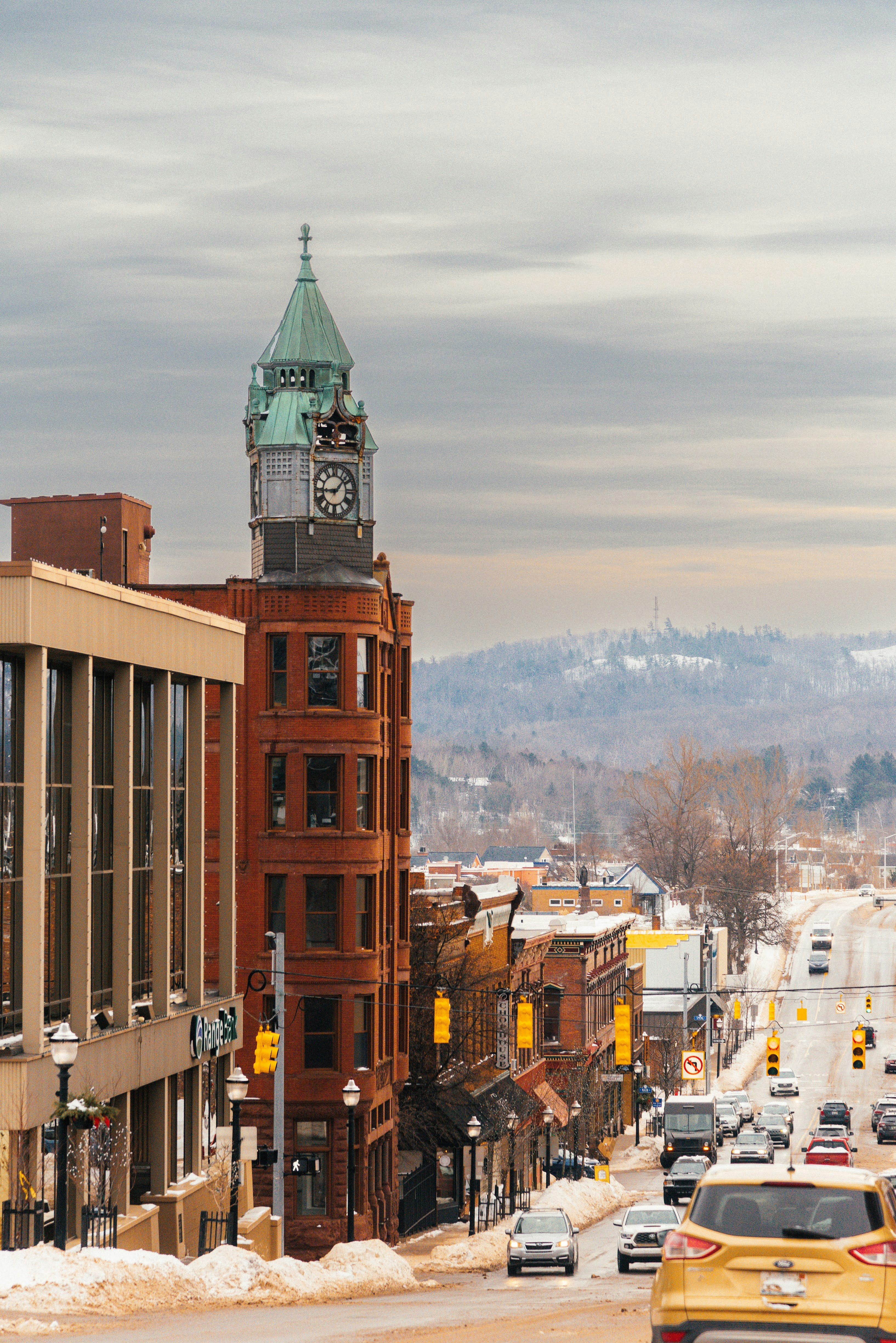 a city street filled with lots of traffic next to tall buildings