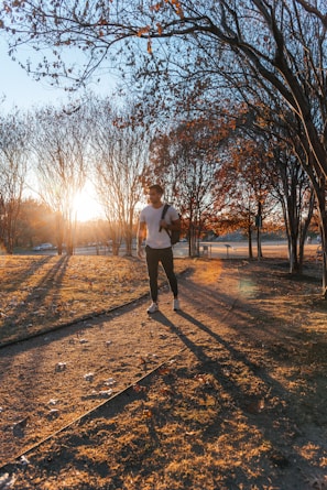 An energetic man jogging in a park during sunrise.
