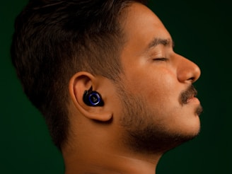 User wearing wireless earbuds, immersed in a frequency-based stimulation session at home.